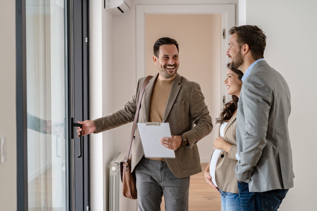 A young couple with a real-estate agent visiting an apartment fo